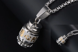 Macro shot of silver and gold stainless steel cylinder pendant with religious engraving