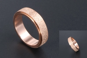 Macro shot of rose gold spinner ring with sandblasted surface and polished inner band