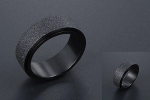 Macro d'une bague rotative noire avec finition sablée mate et texture industrielle chic