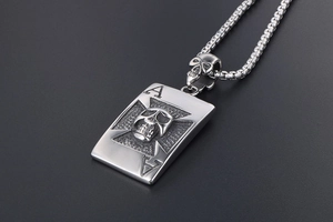 Détail macro du pendentif carte en acier argenté avec crâne 3D et symboles de l'as