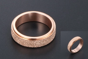 Detail view of rose gold rotatable ring with a frosted finish and polished inner band