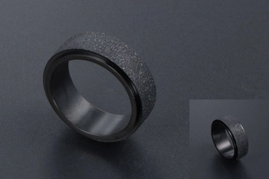 Vue rapprochée d'une bague rotative noire mate avec une finition sablée givrée