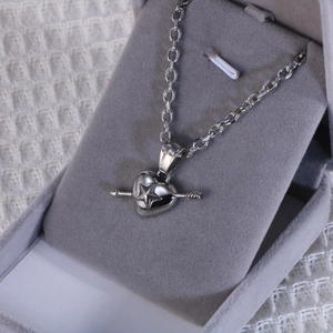 Macro shot of silver heart pendant with star engraving in a velvet jewelry box