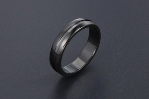 Détail de la bague noire minimaliste polie avec un design épuré à rainure centrale