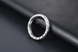 Dettaglio dell'anello in acciaio al titanio argento con trama a corda intrecciata