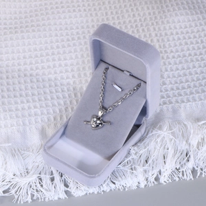 Macro shot of titanium steel heart pendant with Cupid arrow in a velvet jewelry box