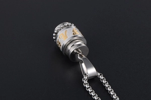 Macro shot of silver stainless steel rotating pendant necklace with golden characters