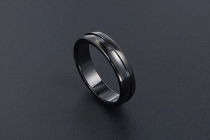 Gros plan sur une bague noire polie minimaliste avec rainure centrale élégante