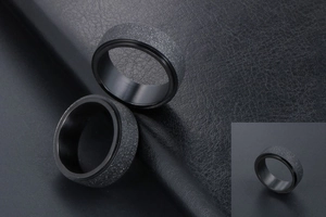Détail macro d'une bague rotative noire mate avec paillettes argentées sur cuir noir