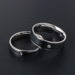 Bagues de couple en acier titane poli avec rayures noires et un cristal de zircon