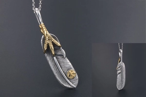 Macro detail of silver eagle claw feather pendant with antique textured finish