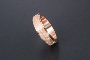 Detail view of rose gold rotatable ring with frosted finish and smooth inner surface