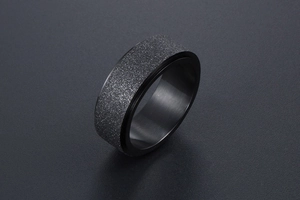 Gros plan sur la bague rotative noire givrée avec surface mate texturée pour hommes
