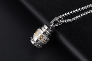 Macro shot of stainless steel Buddhist mantra pendant necklace on black leather surface