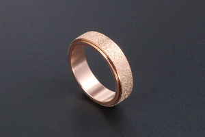 Macro view of rose gold rotatable ring featuring a frosted sandblasted texture