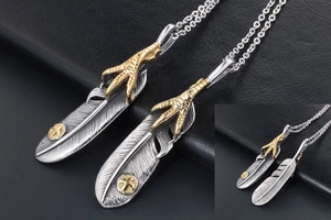 Close-up of vintage engraved silver feather pendant with golden eagle claw detail
