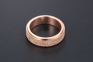 Macro view of rotating rose gold titanium ring featuring a frosted matte texture