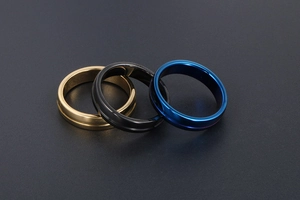 Vue détaillée de trois bagues minimalistes en or, noir et bleu avec rainures centrales