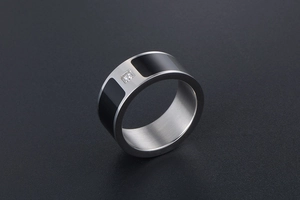 Macro shot of silver titanium steel ring featuring black enamel inlay and a square crystal