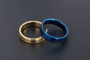 Détail de bagues superposées en acier inoxydable poli or et bleu avec bandes rainurées
