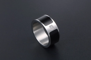 Macro shot of titanium steel ring featuring black enamel inlay and centered zircon stone