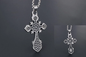 Macro detail of gothic titanium steel cross pendant with retro vintage engraving