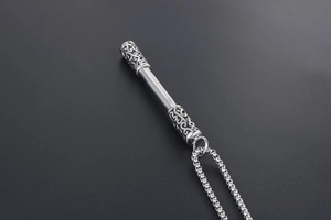 Macro shot of silver metal pendant with intricate hollow cloud patterns on the tips