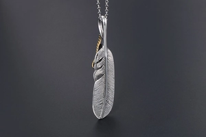 Detailed macro shot of vintage feather pendant with gold accents and clear textures