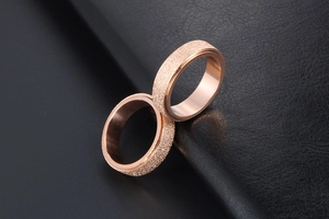 Detail view of rose gold matte finish rings with smooth polished inner surface on leather