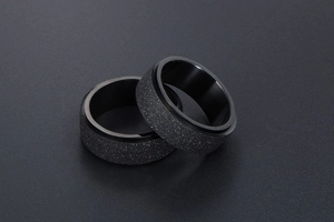 Détail macro de bagues rotatives noires dépolies avec une texture scintillante homme