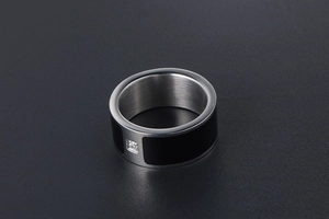 Detailed close-up of a titanium steel ring featuring black enamel inlay and a square zircon
