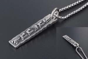 Detail showing vintage titanium steel pendant with embossed religious characters on box chain