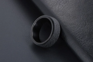 Vue macro d'une bague tournante noire mate pour homme avec finition sablée sur cuir