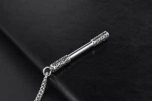Detailed close-up of Ruyi Jingu Bang pendant with intricate cloud engravings on black leather