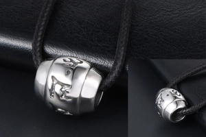 Macro shot of silver titanium steel mantra bead pendant with detailed scripture engraving