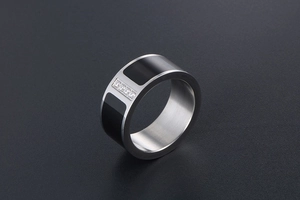 Detail of wide titanium steel ring with black enamel inlay and four inset diamonds