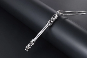 Macro detail of Ruyi Jingu Bang pendant with vintage cloud patterns on steel chain