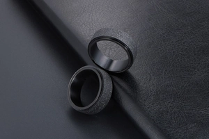 Détail macro d'une bague rotative homme avec finition noire givrée et paroi intérieure polie