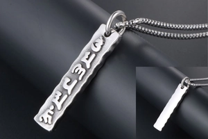 Macro view of rectangular stainless steel pendant with embossed Sanskrit characters and smooth back