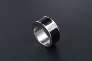 Close-up of titanium steel ring featuring black enamel inlay and four inset diamonds