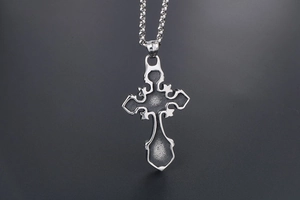 Detail of vintage gothic cross pendant with matte finish and beaded ball chain