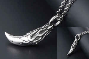 Macro shot of silver retro wolf fang pendant with flame patterns and antique cracked details