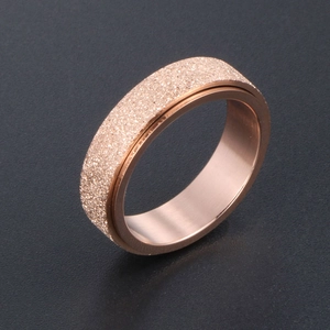 Minimalist rose gold titanium ring with a matte sandblasted finish and rotating design