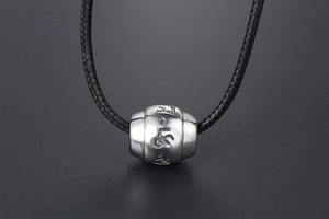 Detailed macro view of silver steel mantra bead with engraved Om Mani Padme Hum characters