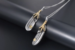 Detail view of retro feather pendants with gold eagle claws and silver textures