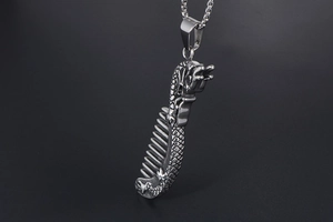 Detailed view of dragon-themed comb pendant made of polished stainless steel and box chain