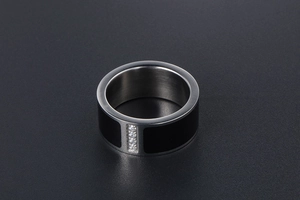 Macro shot of titanium steel couple ring with black glaze and four inlaid diamonds