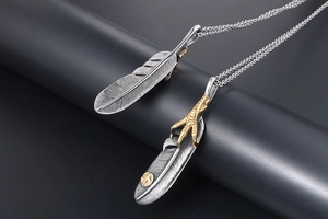 Macro view of Indian style silver feather pendant with golden eagle claw and logo