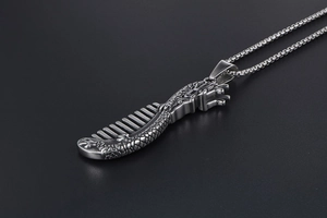 Macro shot of silver titanium steel dragon comb pendant with intricate scales and box chain
