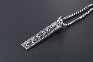 Macro detail of men's vintage titanium steel necklace with engraved mantra pendant